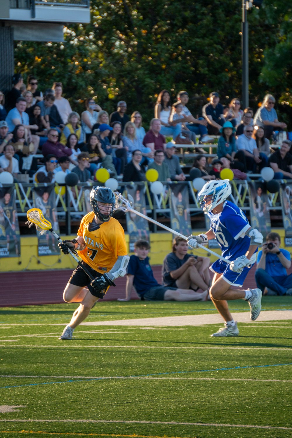 Two lacrosse athletes competing on the field